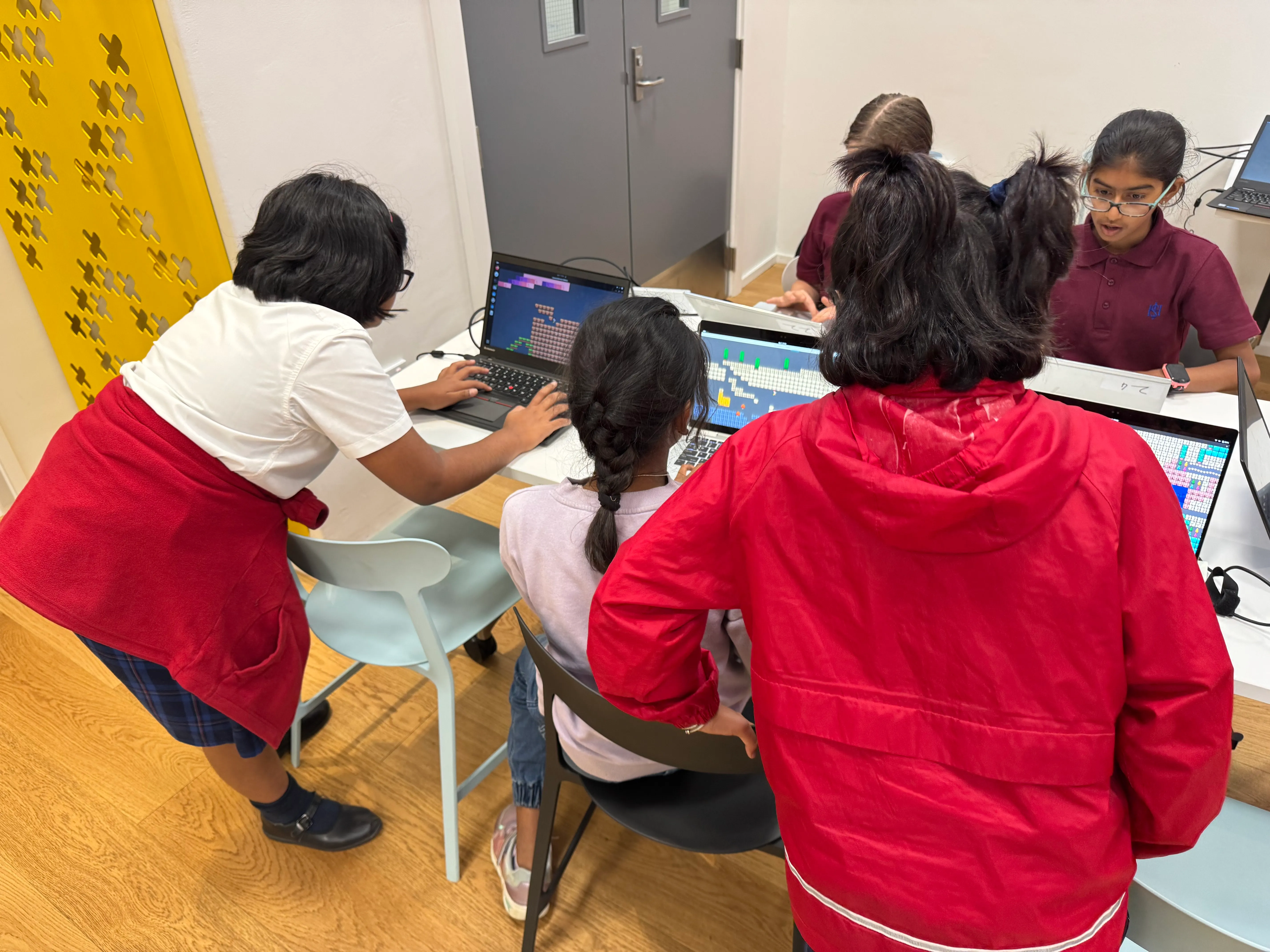 Students collaborating on technology projects during after-school session